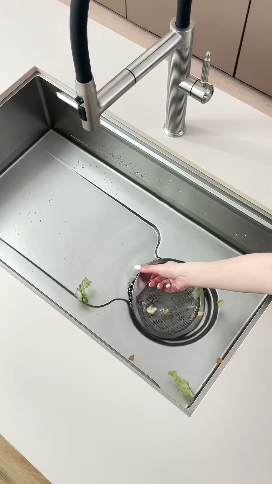 Water and food debris moving along formed drainage lines toward the removable mesh basket